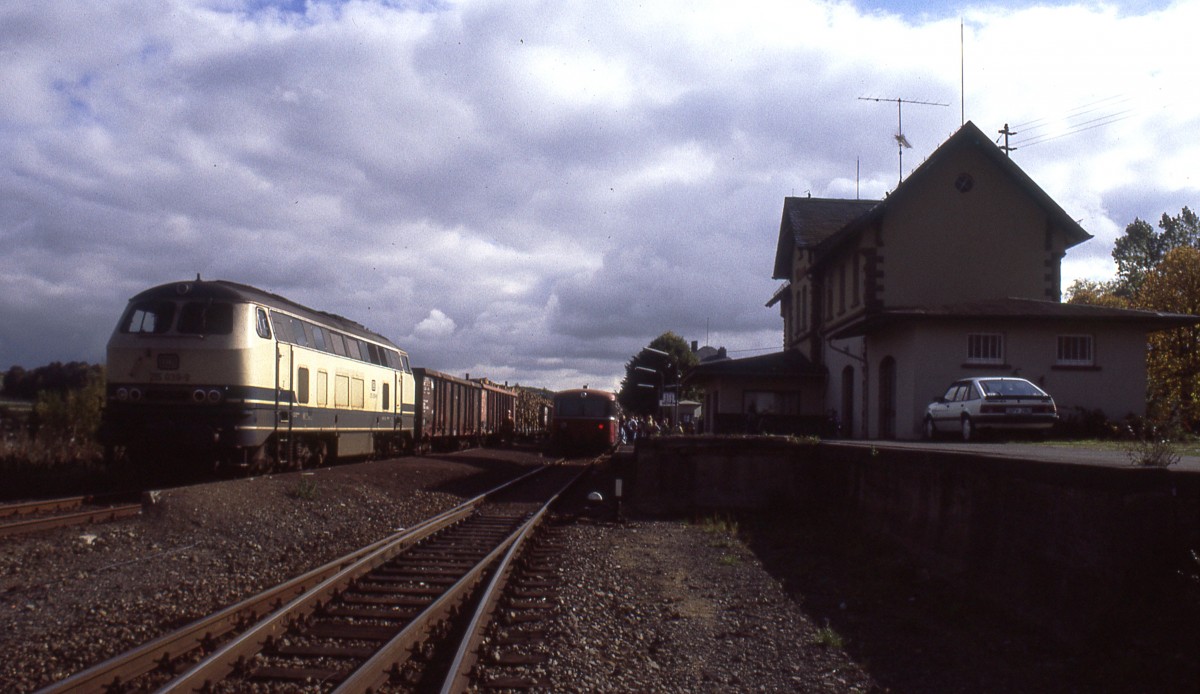 Im Herbst 1990 entstand gegen Mittag diese Aufnahme im Bahnhof vom Ulmen. Das liegt an der KBS 602 zwischen Gerolstein und Mayen. Links steht 215 039-9, die wenig später Richtung Daun weiter fuhr; rechts steht ein Nahverkehrszug aus Daun nach Mayen Ost. Damals fuhren noch planmäßig drei Nahvekehrszüge je Richtung. Im Jahr 1991 wurde der Personenverkehr dann zwischen Gerolstein und Mayen Ost eingestellt. Nikon F301 - Scan vom Dia. 