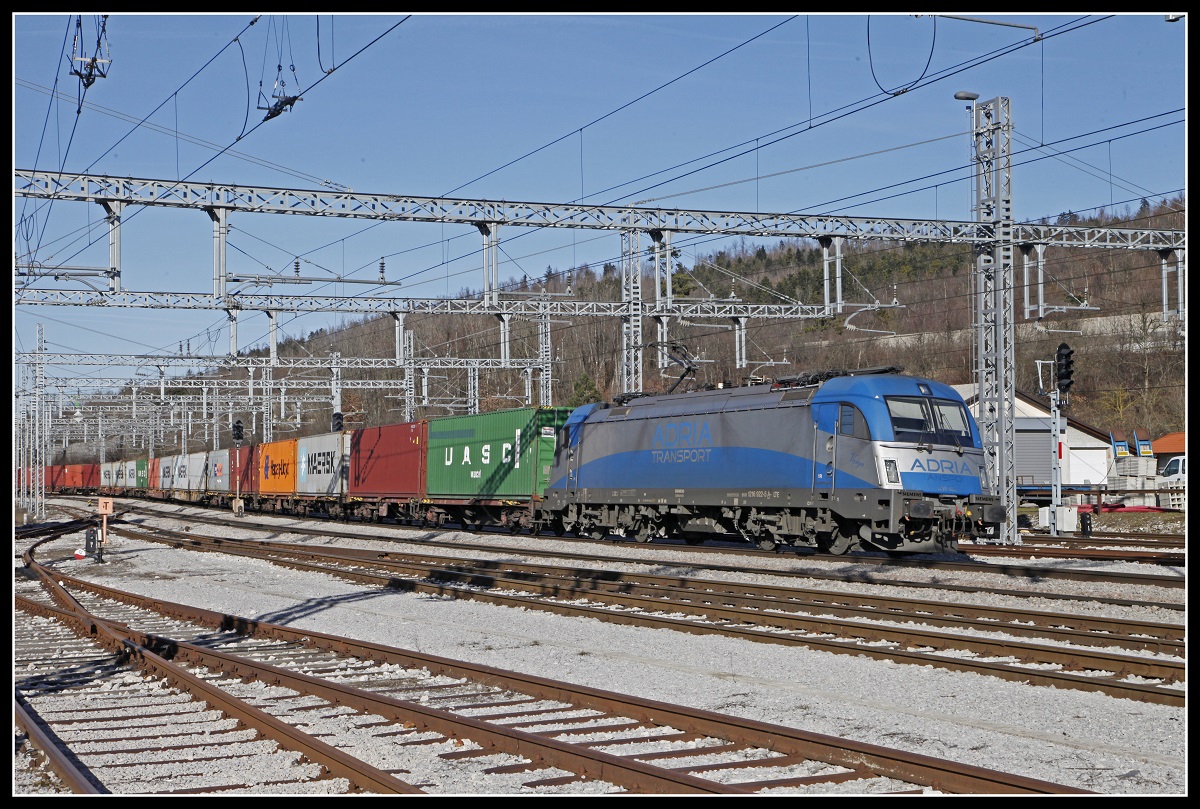 Im Jahr 2014 wurde die Oberleitung des Bahnhofes Postojna durch einen Eisregen zerstört. Seitdem beherscht der wuchtige Neubau der Fahrleitung die Szenerie des Bahnhofs. Hier zu sehen mit der 1216 922 mit Güterzug am 13.02.2019.