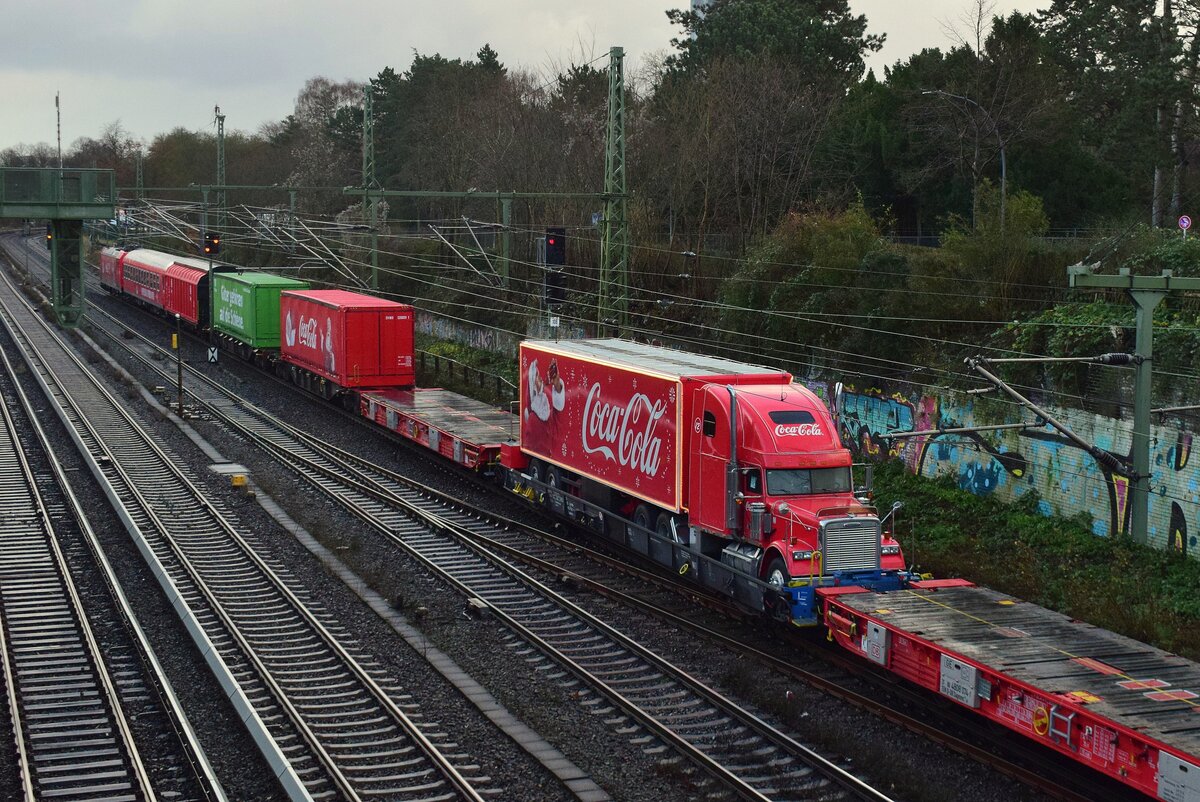 Im Jahr 2023 wurde zum ersten Mal neben den Coca Cola Trucks auch ein Coca Cola Zug durch Deutschland geschickt. Dafür wurden 185 204 und 185 207 extra geschwaschen und beklebt. Ebenso passend farbene Güterwagen und 2 Reisezugwagen von Gff. Das Highlight des Zuges war der Coca Cola Truck auf dem Rola Wagen in der Zugmitte. Hier fährt der Zug zwischen Hamburg Hbf und Hamburg Altona im Gegengleis da er nur über die innere Kurve Gleis 12 erreichen kann und in Kürze ein IC nach Kopenhagen über das Regelgleis fährt. 

Hamburg 20.12.2023