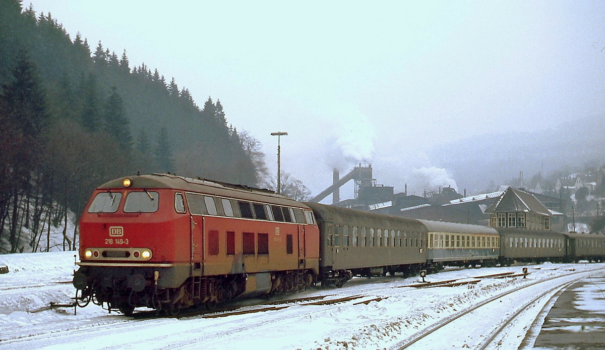 Im Januar 1979 fährt die 218 149-3 mit einem D-Zug in Brilon Wald ein, im Hintergrund die chemische Fabrik der Degussa, in der hauptsächlich Aktivkohle produziert wurde. 1995 wurde die Fabrik stillgelegt und die Anlagen abgerissen. 