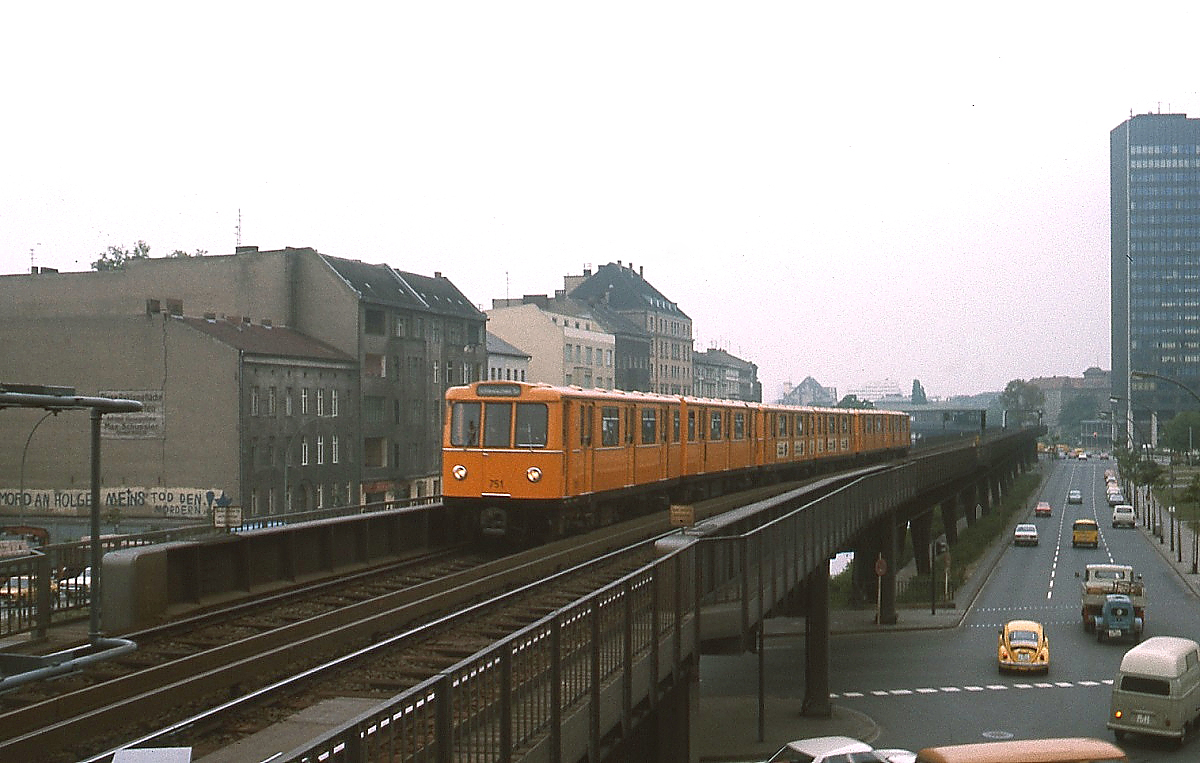 Im Januar 1981 ist ein U-Bahn-Zug der Linie 1 auf dem oberirdischen Streckenabschnitt in Kreuzberg zum Schlesischen Tor unterwegs. Der führende Triebwagen 751 gehört zur Baureihe A3L 71. Zeittypisch sind nicht nur die Pkw, sondern auch die Parole links an der Hauswand.