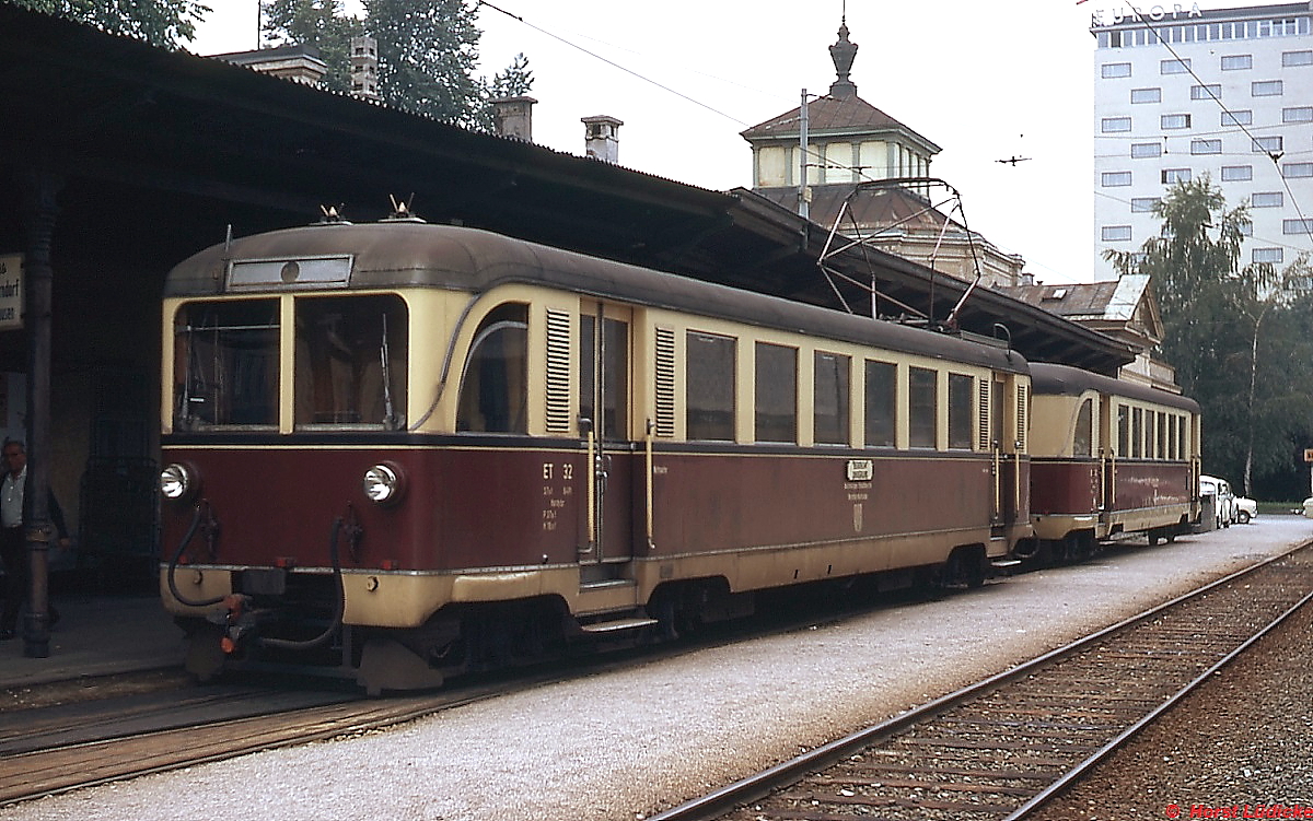 Im Juli 1973 steht ET 32 der Salzburger Lokalbahnen im Salzburger Lokalbahnhof abfahrbereit vor einem Zug nach Lamprechtshausen. Damals existierte noch das Bahnhofsgebäude aus der Anfangszeit, von der anderen Seite fuhren bis 1957 die Züge der schmalspurigen Salzkammergut-Lokalbahn nach Bad Ischl ab.