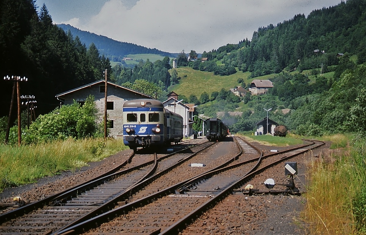 Im Juli 1991 verlässt 5146 203-4 mit dem Steuerwagen 5646 214-5 an der Spitze den Bahnhof Hüttenberg. Die dortigen Erzvorkommen waren der Grund, dass die Kronprinz Rudolf-Bahn schon 1869 eine Strecke ins Görtschitztal baute. Ende der 1970er Jahre war es vorbei mit dem Erzabbau und die Görtschitztalbahn verlor rasch an Bedeutung. 1995 wurde der Personenverkehr eingestellt und heute ist der Abschnitt zwischen Wieting und Hüttenberg stillgelegt.
