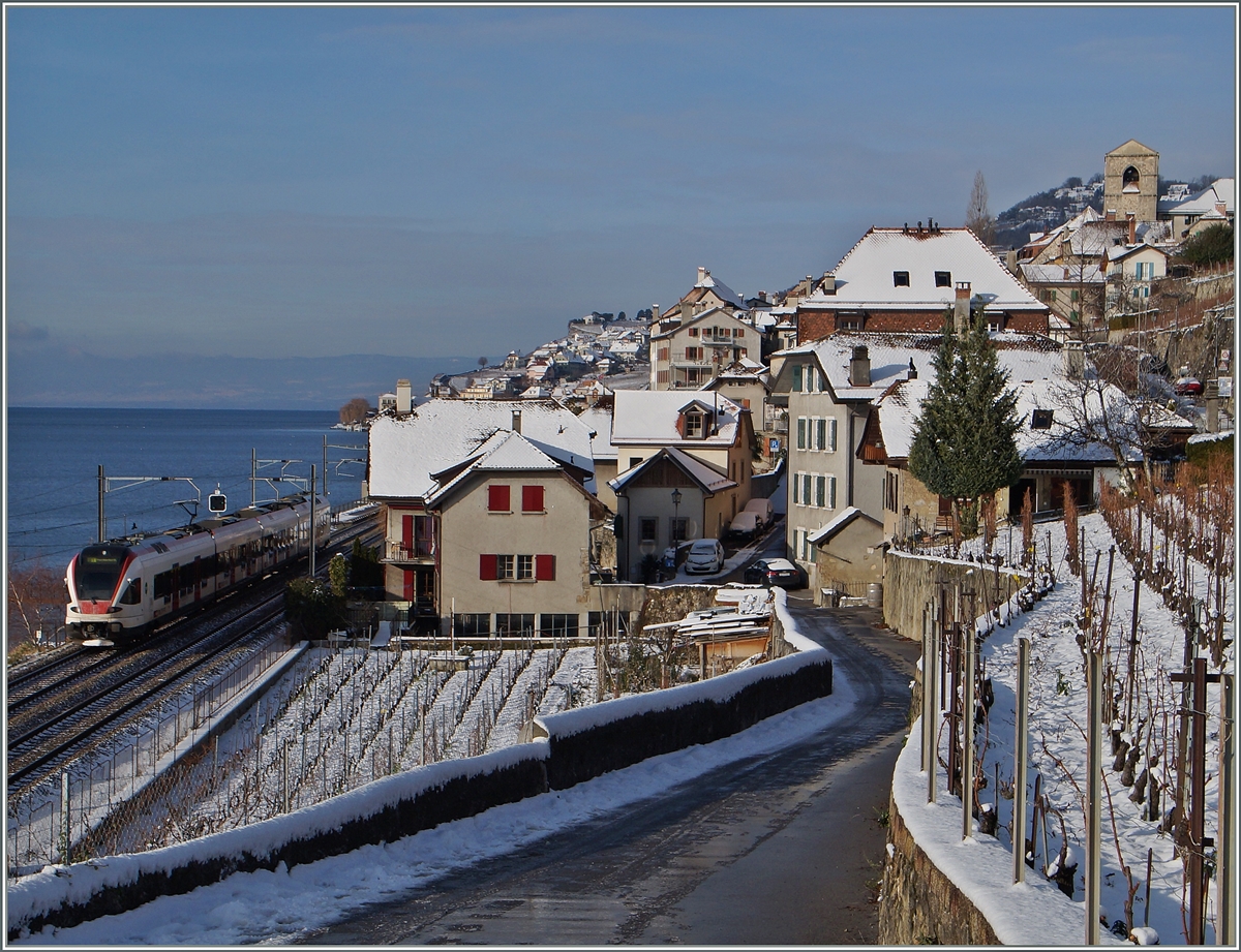 Im leicht verschneiten Lavaux ist ein SBB FLIRT RABe 523 auf dem Weg Richtung Lausanne bei der Ankunft in St-Saphorin zu sehen.. 

30. Dez. 2014