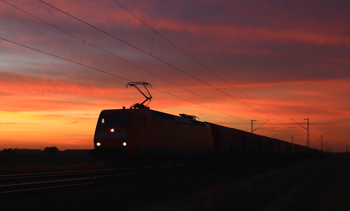 Im letzten Licht des Tages ist eine unbekannte 145 am 31.10.2014 mit einem Güterzug bei Nievenheim in Richtung Köln unterwegs