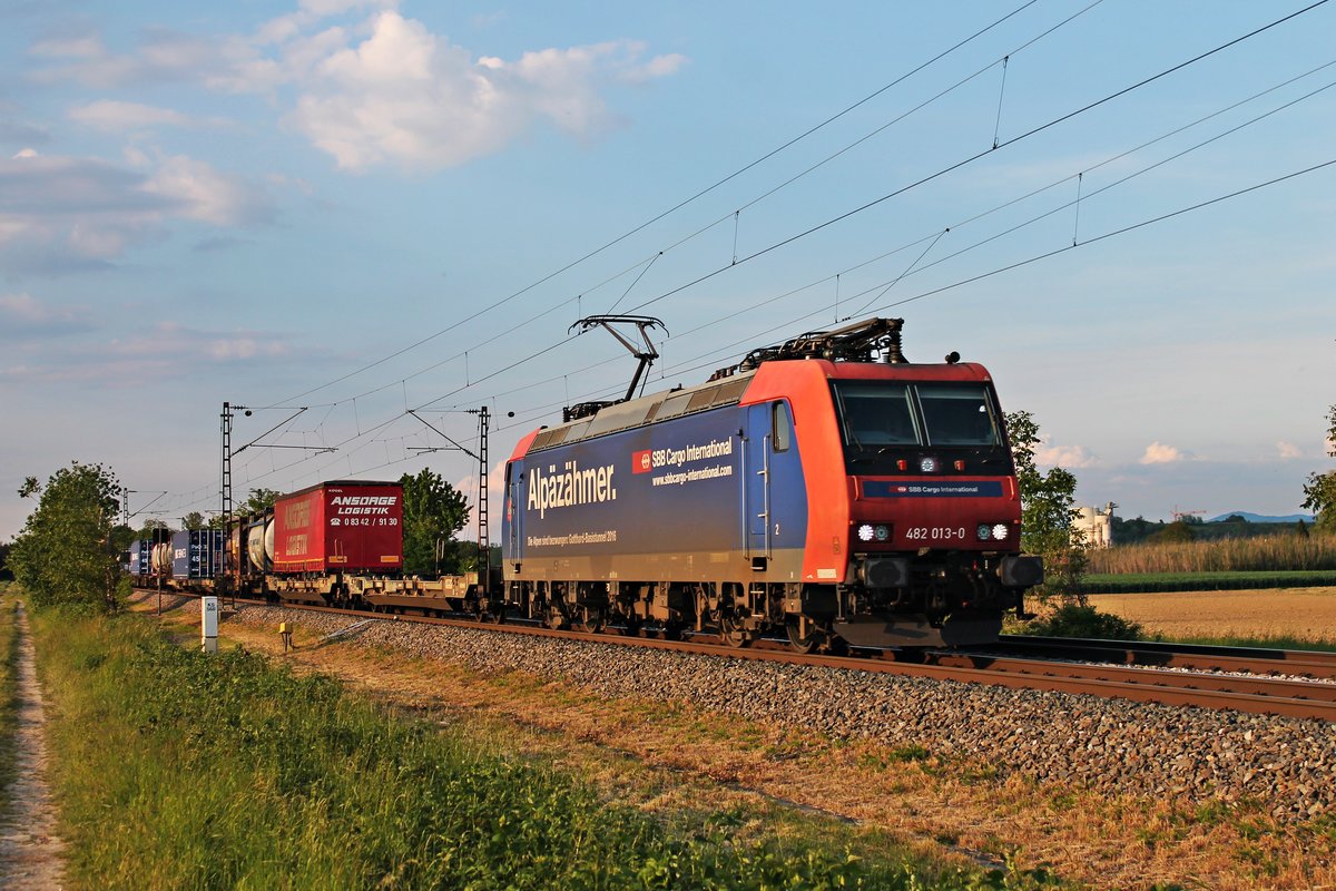 Im letzten Sonnenlicht des 24.05.2019 fuhr die Re 482 013-0  Alpäzähmer  mit einem langen und bunten Containerzug zwischen Buggingen und Hügelheim über die KBS 703 durchs Markgräflerland in Richtung Schweizer Grenze.