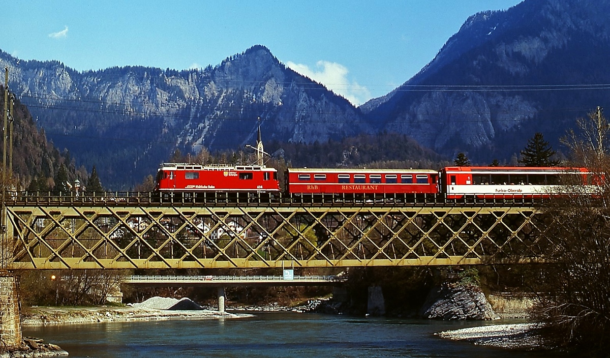 Im März 1996 überquert die Ge 4/4 II 634 mit dem Glacier Express den Zusammenfluss von Vorderrhein und Hinterrhein bei Reichenau Tramins, hinter der Lok sind der 1984 gebaute Speisewagen WR 3815, der 2004 eine blaue Farbgebung erhielt, und ein 1. Klasse-Panoramawagen der Furka-Oberalp-Bahn eingereiht
