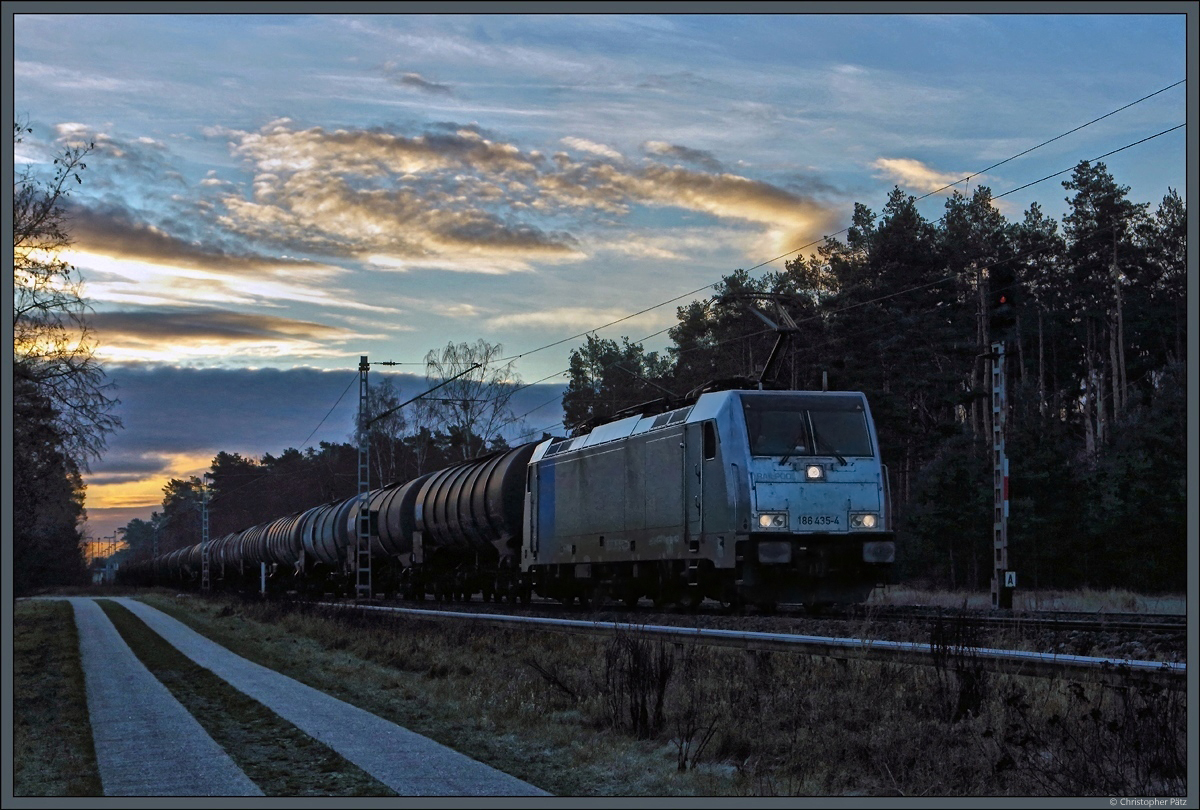 Im Morgengrauen passiert die an HSL vermietete 186 435-4 mit einem Kesselzug die Bk Wahlitz zwischen Gommern und Königsborn. Rechts das Signal A der Blockstelle. (30.12.2020)
