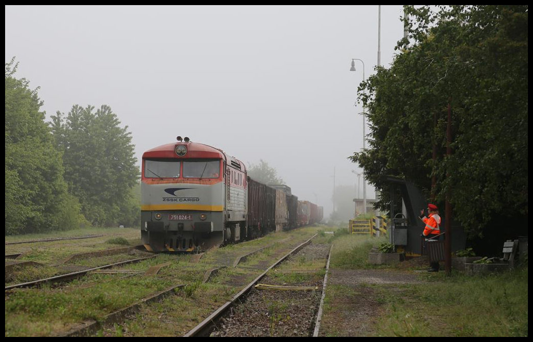 Im Morgennebel des 17.5.2019 fährt die Bardotka 751024-1 mit dem Güterzug 83710 nach Nove Zamky um 8.52 Uhr durch den Bahnhof Mana. Der Lokführer bekommt dabei einen netten Gruß der Fahrdienstleiterin.