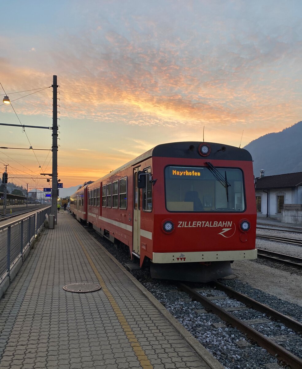 Im Morgenrot des 15. September 2021 steht der R 121 der Zillertalbahn im Ausgangsbahnhof Jenbach zur Fahrt nach Mayrhofen bereit. Gebildet ist die Leistung aus den Triebköpfen VT 8 und VT 6 (hier am Zugschluss). 