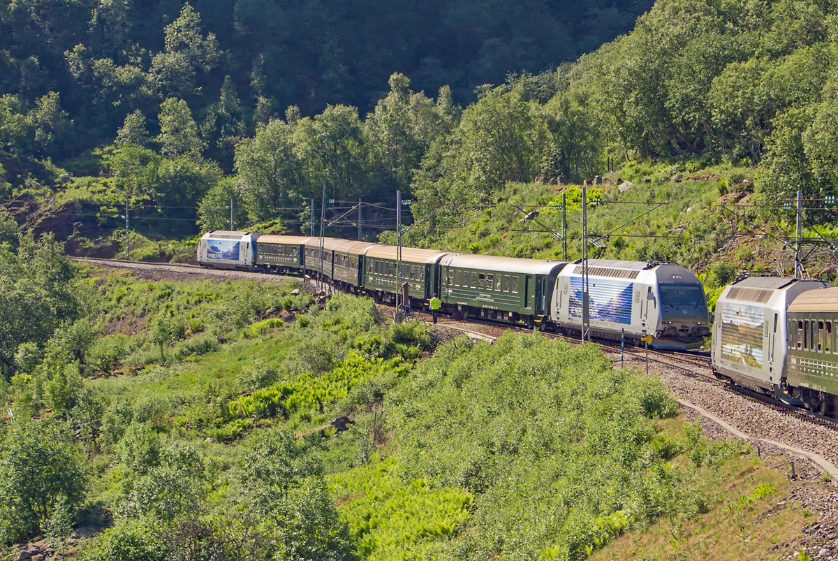 Im Nicht-Winter-Betrieb auf der Flamsbahn von Flam am Aurland-Fjord nach Myrdal an der Bergenbahn, der von Anfang April bis Ende Oktober währt, ist aufrund der Zugdichte eine Begegnung unterwegs vorgesehen. Dafür ist der Halt Berekvam vorgesehen, an anderen Stellen gibt es kein Ausweichgleis. Interessant ist hier, dass die Weichen vor Ort von einem Angestellten der Bahn bedient werden, der die Einfahrt auch per Flagge regelt. Am 31.10.2018 begegnen sich hier der bergwärts fahrende Zug 1856, der wie alle Züge aus 6 Wagen besteht und im Sandwich von El 18 2252 (vorn) und El 18 2247 (hinten) befördert wird. Von diesem Zug aus kann man gut den einfahrenden Zug 1855 beobachten, der sich auf das Ausweichgleis schlängelt. Dieser wird befördert von El 18 2255 (vorn) und El 18 2246 (hinten). Somit stehen insgesamt 10.800 kW pro Zug zur Verfügung, ein stolzer Wert.