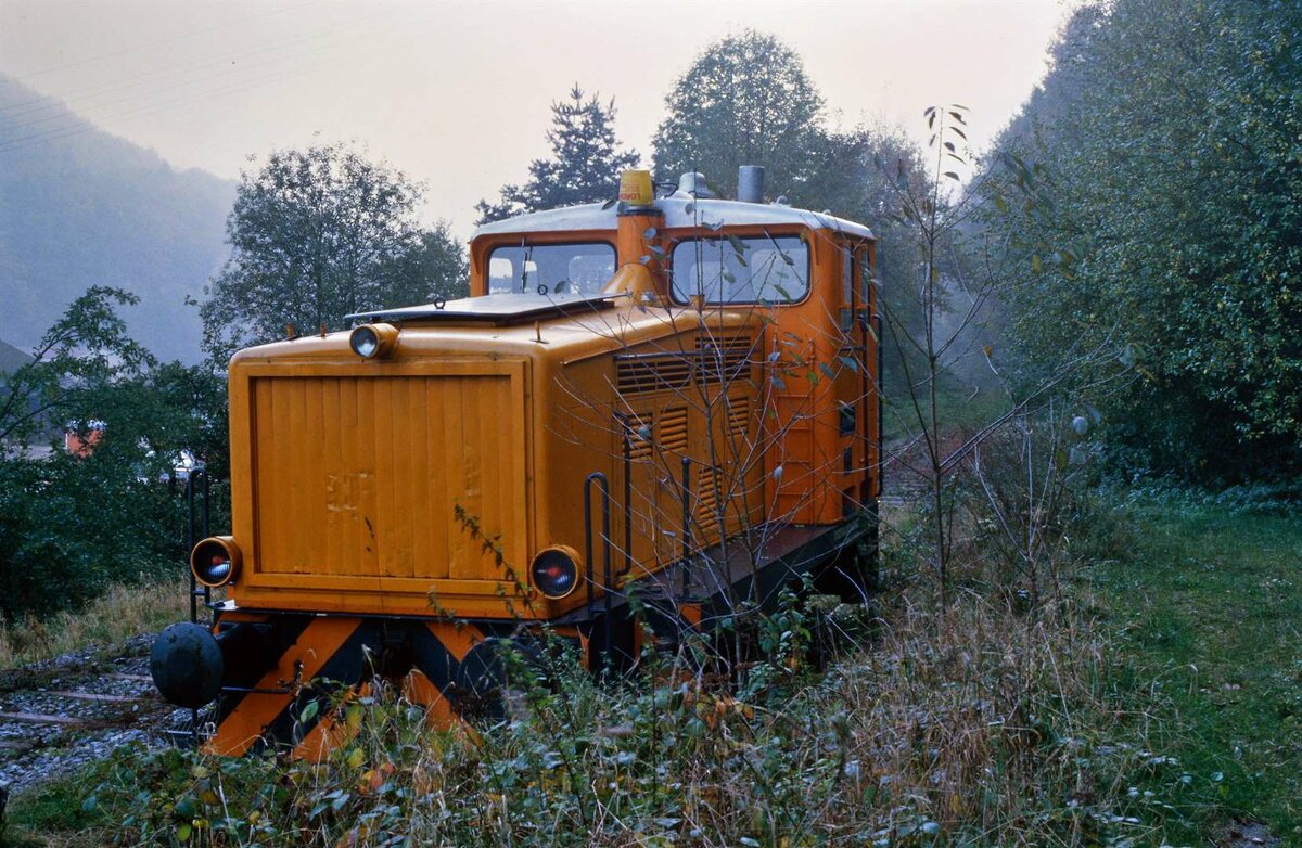 Im November 1984 finden sich nur noch Reste der früheren DB-Bahnstrecke Neckarsteinach-Schönau. Hier ist eine Diesellok auf dem Areal des Bahnhofs Schönau abgestellt. Es ist die Lok  Leo Breuer  der Gerresheimer Glas AG.  