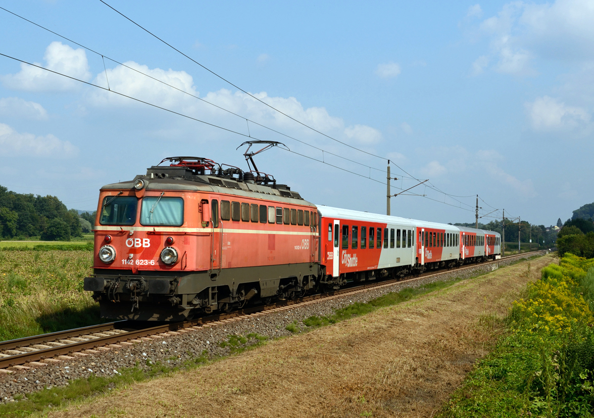 Im sanften Abendlicht war die blutorange 1142 623 am 03. August 2015 mit einer S-Bahngarnitur der Linie S 5 von Spielfeld-Straß nach Graz Hauptbahnhof unterwegs und wurde von mir bei Wildon fotografiert. 
