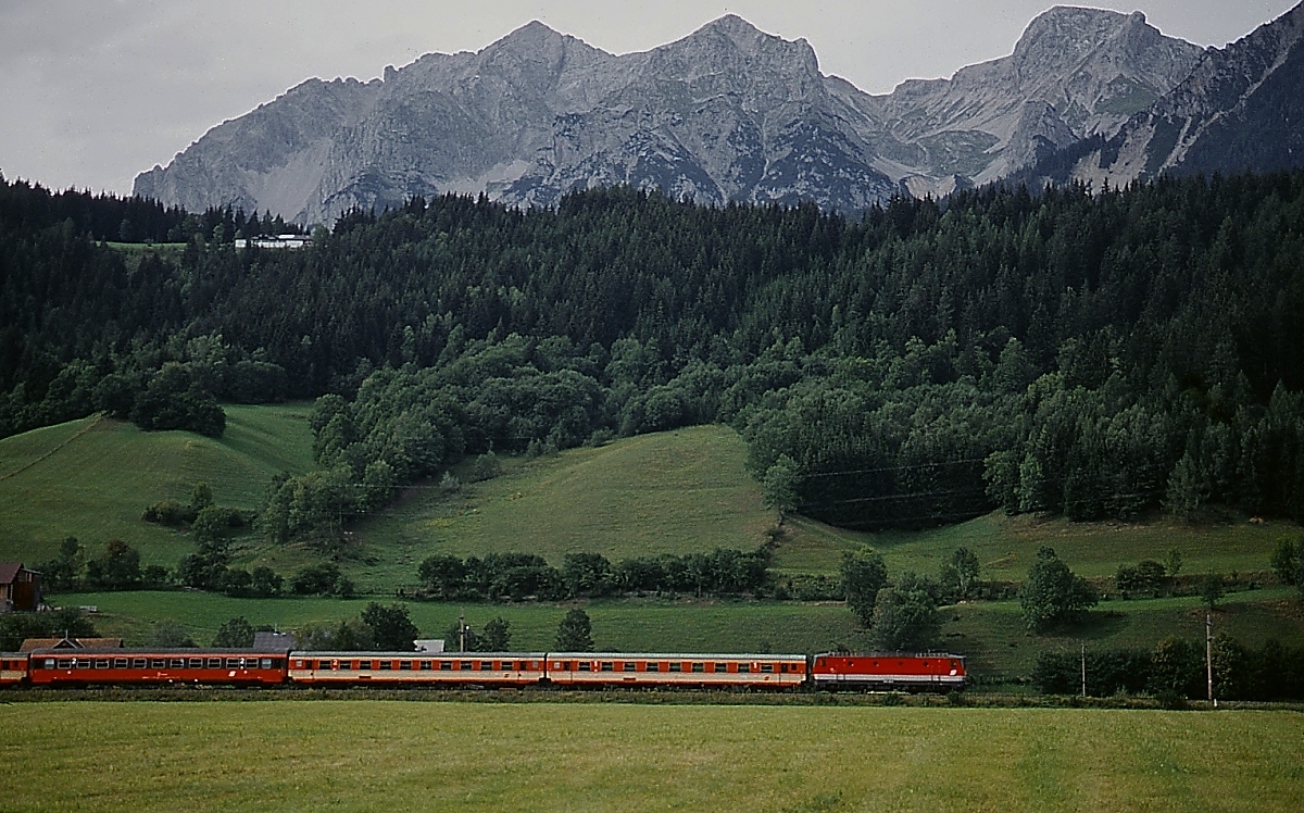 Im September 1992 ist eine 1044 mit einem Schnellzug im Ennstal zwischen Schladming und Haus unterwegs, im Hintergrund das Dachsteinmassiv