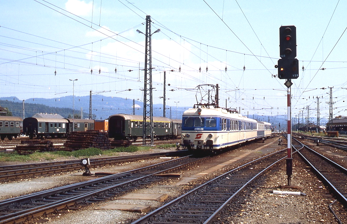 Im Sommer 1981 fährt 4130.02 in den Villacher Hauptbahnhof ein. Die im Gleisvorfeld abgestellten Wagengarnituren wurden damals noch im Alltagsdienst eingesetzt.