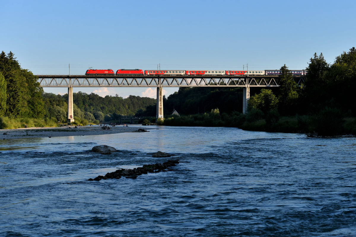 Im Sommer 2018 fanden umfangreiche Bauarbeiten auf der KBS 950 zwischen Ostermünchen und Rosenheim statt. Um diese Strecke zu entlasten, wurden einige Züge planmäßig über Holzkirchen umgeleitet. Regelmäßig war dies der NJ 295 nach Roma Termini. So kam meine  Hausstrecke  - auf der sonst gähnende Langeweile herrscht - sogar zu etwas internationalem Flair. Am 20. Juni 2018 ergab sich darüber hinaus die betriebliche Besonderheit, dass der regulären 101 ein ÖBB Taurus vorgespannt wurde, um eine zusätzliche Überführungsfahrt zu sparen. Kurz vor 20 Uhr überquerten 1116.178 und 101 041 mit dem aufgrund der Umleitung als IC 60295 bezeichneten Zug die Großhesseloher Brücke. 
