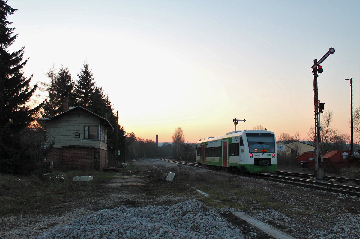 Im Sonnenuntergang des 1.3.2023 verlässt der VT321 der Erfurter Bahn (EB) als RE12 (Leipzig Hbf-Saalfeld/Saale) den oberen Bahnhof von Pößneck in Richtung Zielbahnhof Saalfeld.  