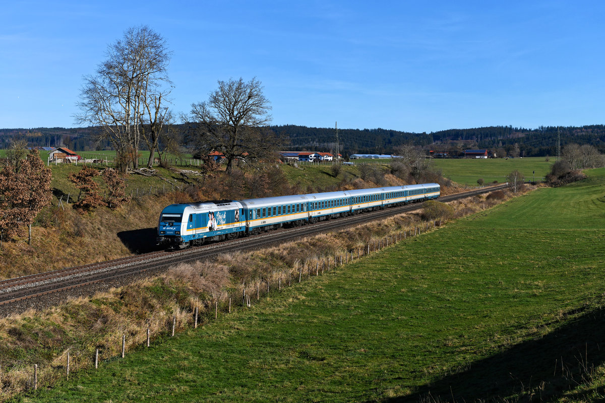 Im Spätherbst 2020 hieß es für die Alex-Züge  Pfüad di, Allgäu . Nach 17 Jahren gingen die Leistungen südlich von München wieder an DB Regio. Aus Fotografen-Sicht stellt der Wegfall der lokbespannten klassischen Reisezüge einen herben Verlust dar. Am 14. November 2020 konnte ich die 223 072 mit ihrer Seitenwerbung für eine regionale Trachtengruppe vor dem ALX 84108 auf der Fahrt nach Lindau bei Aitrang im Ostallgäu fotografieren.  