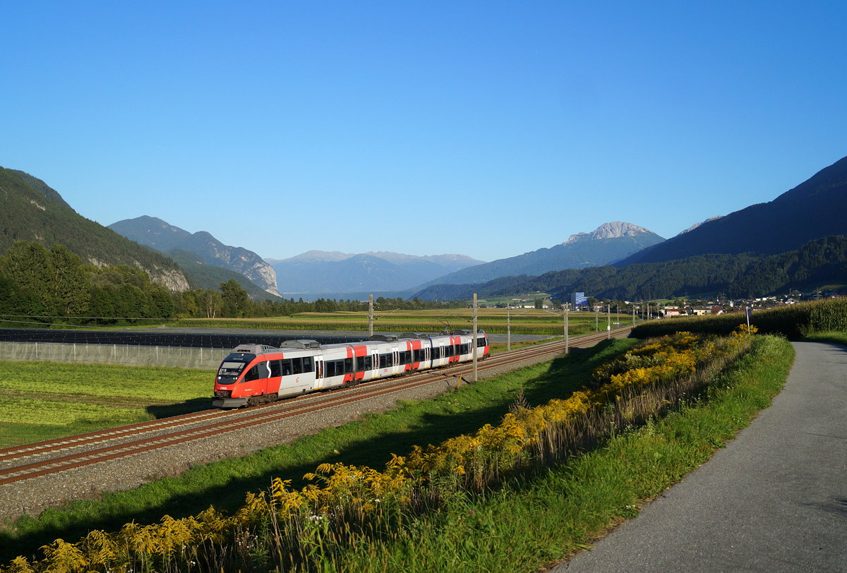 Im spätsommerlichen Abendlicht ist der ÖBB 4024 095-4 als Zug 5166 von Jenbach nach Ötztal (S 2) unterwegs und hat soeben die Ortschaft Flaurling an der Arlbergbahn hinter sich gelassen, 04.09.2019.
