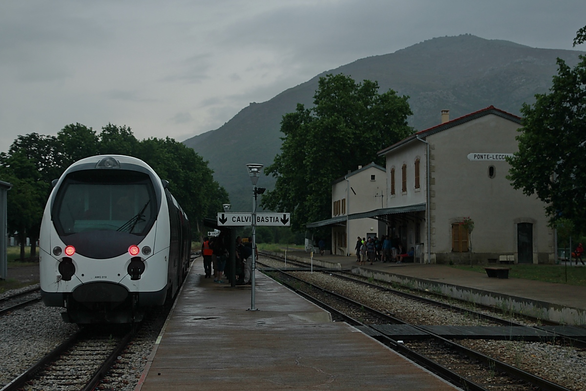 Im strömenden Regen und damit ganz anders als drei Tage zuvor präsentiert sich der Bahnhof Ponte-Leccia am 15.06.2014 bei der Ankunft von AMG 819/820 aus Calvi