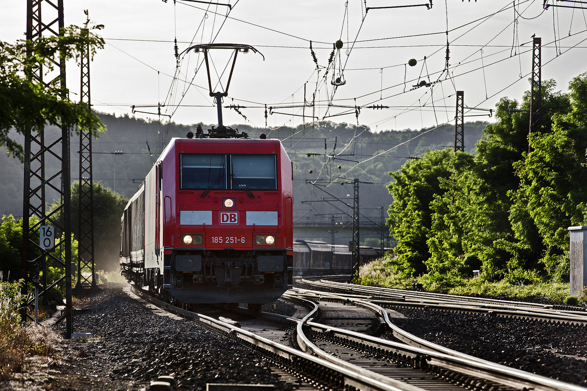 Im vollen abendlichen Gegenlicht donnert die 185 251-6 mit einem Schiebewandwagenzug in Retzbach vorüber.Bild vom 12.6.2017