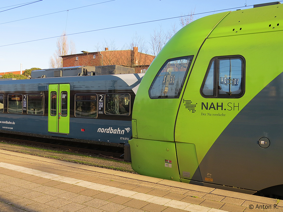 Im Vordergrund ist ein Nordbahn-FLIRT zu sehen, welcher am 25.12.2015 in Itzehoe auf seine Rückfahrt als RB61 nach Hamburg Hbf gewartet hat. Dahinter versteckt sich ein abgestellter FLIRT der Nordbahn mit der Anzeige  Frohe Weihnachten .
Die FLIRT-Triebzüge der Nordbahn tragen das dem ersten NAH.SH-Corporate Design entsprechende Farbschema von 2010, welches jedoch bereits nicht mehr aktuell ist.