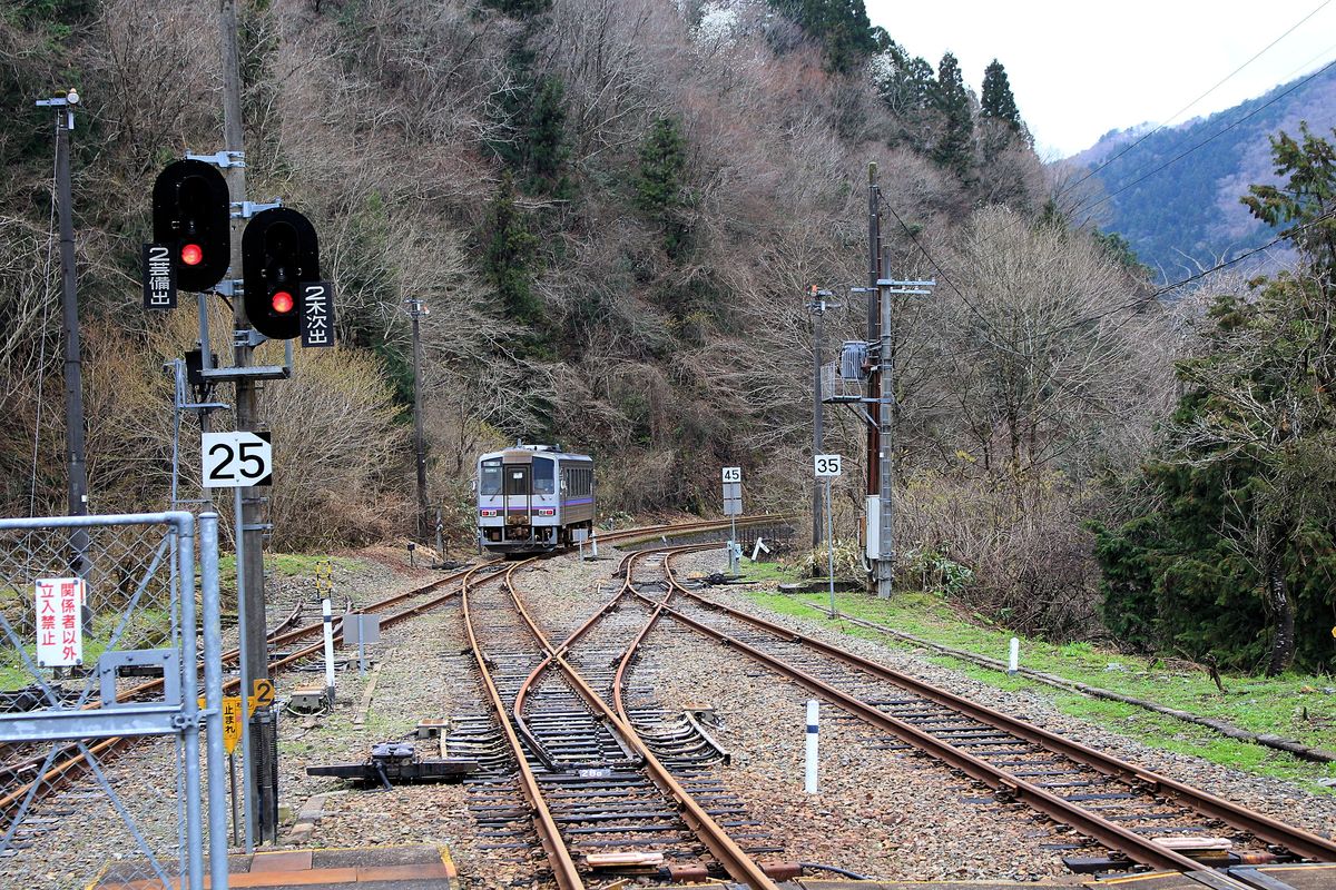 Im westjapanischen Hochland-Bahnhof Bingo Ochiai trifft die Linie vom Japanischen Meer her mit der Hochland-Linie zusammen. Dass hier kaum noch Züge fahren sieht man am Rost auf den Gleisen. Triebwagen KIHA 120-21 fährt auf der Hochland-Linie nach Westen fort. 5.April 2015 