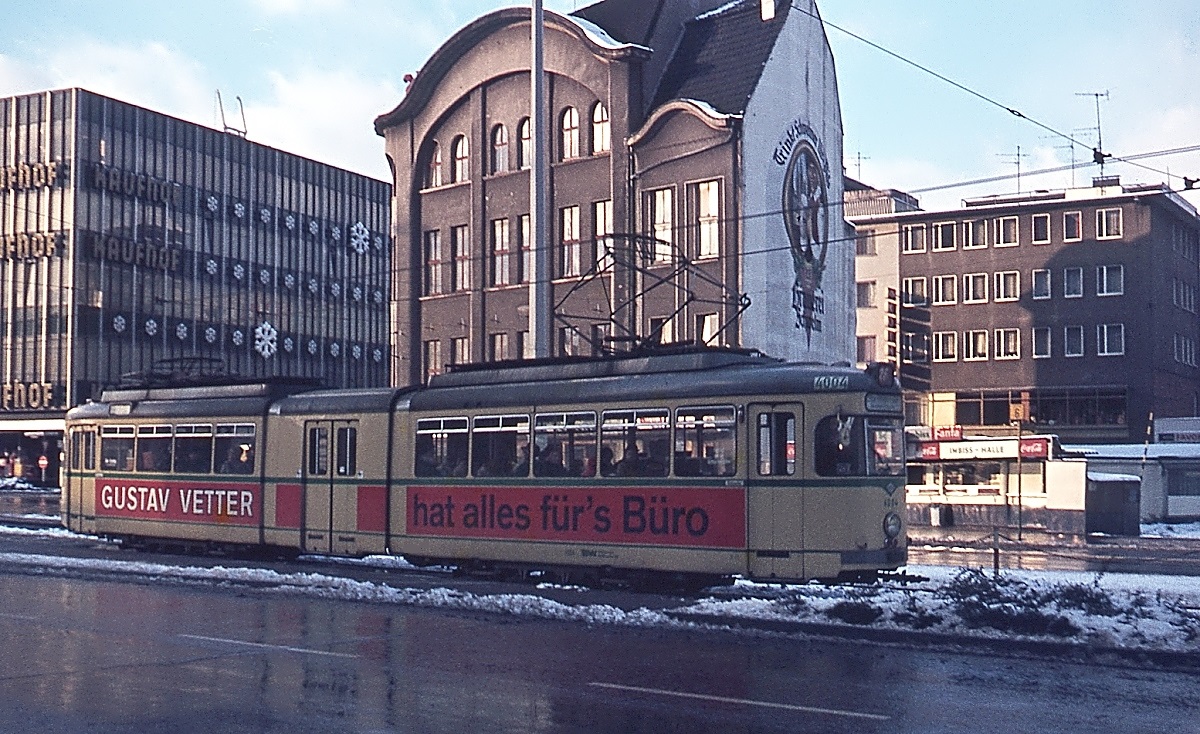 Im Winter 1973/74 ist der Wuppertaler Gelenkvierachser 4004 in Wuppertal-Barmen unterwegs. Diese Fahrzeuge wurden 1961 auf alten Zweiachser-Fahrwerken zu Gelenkwagen mit schwebenden Mittelteil umgebaut. Wegen der schlechten Laufeigenschaften wurden sie schon 1983 ausgemuster und nach Graz verkauft, dort kamen sie allerdings nicht zum Einsatz. Leider hatte ich damals nur eine Kleinbildkamera dabei, deshalb ist die Bildqualität nicht berauschend, es ist allerdings meine einzige Aufnahme von diesem Fahrzeugtyp.