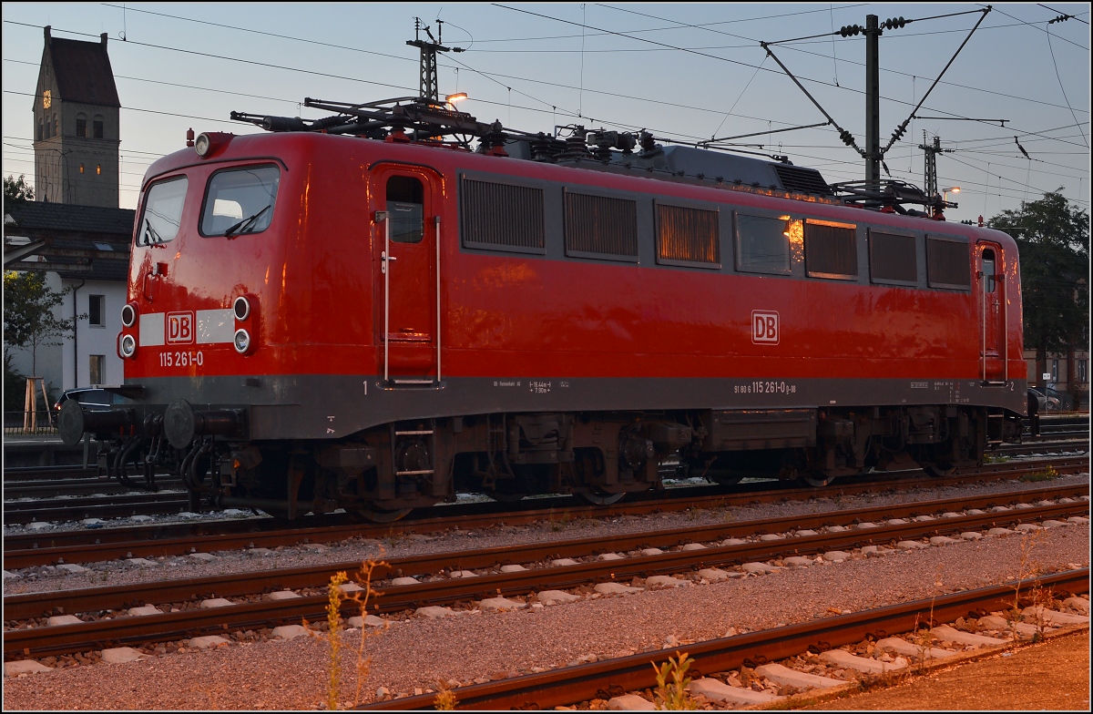 Im Zwilicht, 115 261-0 in Singen am angestammten Parkplatz. Leider gehörte sie zum ganz scheuen Wild und zeigte sich erst, als nur noch ein versprengter Rest der jagenden Meute zugegen war. August, 2015.