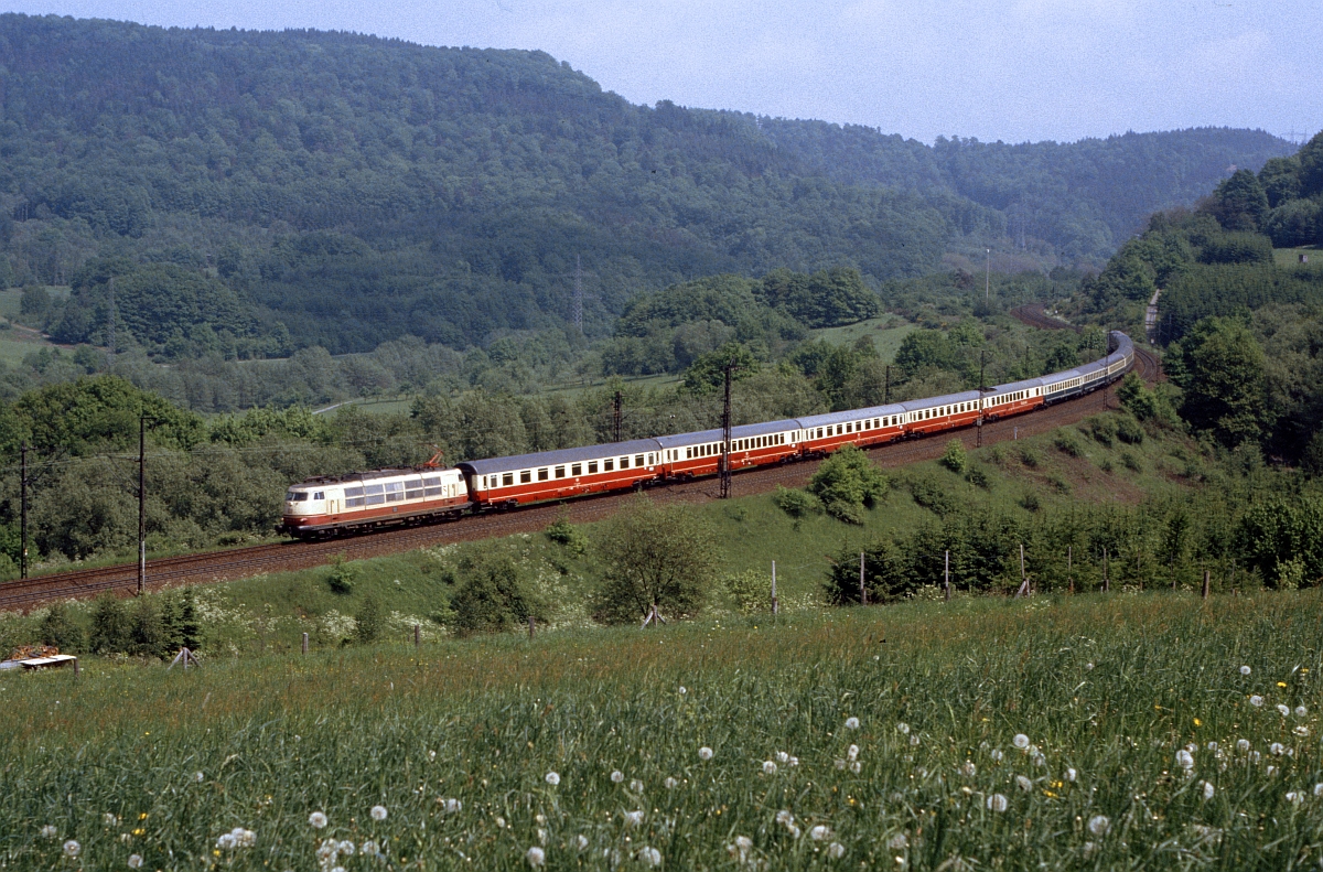 Immer wieder eine Augenweide in ansprechender Landschaft : Klassischer  IC 79  (DB-Werbeslogan  jede Stunde, jede Klasse ) mit unbekannter 103 bei Hain (24.5.1985).