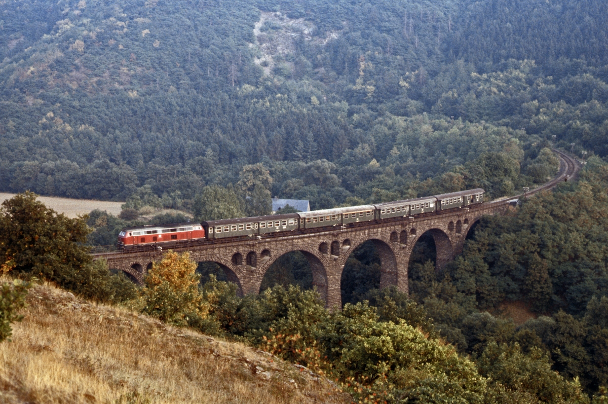 In den 1980er Jahren ein markantes  Muss-Motiv  : Das Viadukt bei Hausen an der Strecke Koblenz - Mayen, ber das heute ein Radweg fhrt. Im September 1982 ist die Gieener 216 133 mit einem der wenigen verbliebenen Personenzge auf dieser Strecke nach Mayen Ost unterwegs.