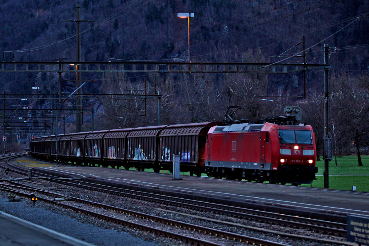 In der Abenddämmerung des 10.2.2016 fährt die DB Lok 185 088-2 mit dem Red Bull Zug in Weesen vorüber.