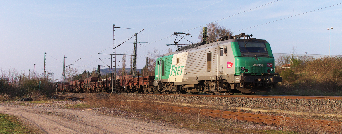 In der Abendsonne auf dem Weg nach Dünkirchen ist der tägliche Brammenzug von der Dillinger Hütte! Am 08.04.2015 hatte SNCF FRET 4 37009 die Aufgabe den Zug an sein Ziel im Norden von Frankreich zu befördern. Bis vor 2 Jahren wurde dieser Zug von zwei G1206 oder einer Class 66 über die Niedtalbahn nach Frankreich transportiert. 
Dann hat man sich entschlossen elektrisch zu fahren und einen Umweg von runden 50 Kilometern einkalkuliert. Bahnstrecke 3230 Saarbrücken - Karthaus am Kraftwerk Ensdorf.