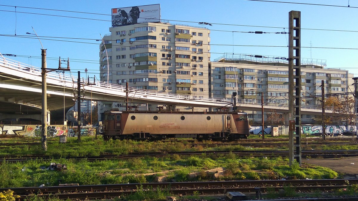 In den Anfangsjahren des vergangenen Jahrzents wurden einige E-Loks der Baureihe 40 durch Siemens in die neue Baureihe 45 umgebaut. Diese bekamen unter anderen neue Stromabnehmer, die nach innen öffneten (ähnloch wie bei Baureihe 43). E-Lok 91-53-0-450379-9 ist eine der wenigen Loks die noch solche Stromabnehmer hat. Sie stand am 21.11.2017 im Nordbahnhof Bukarest.