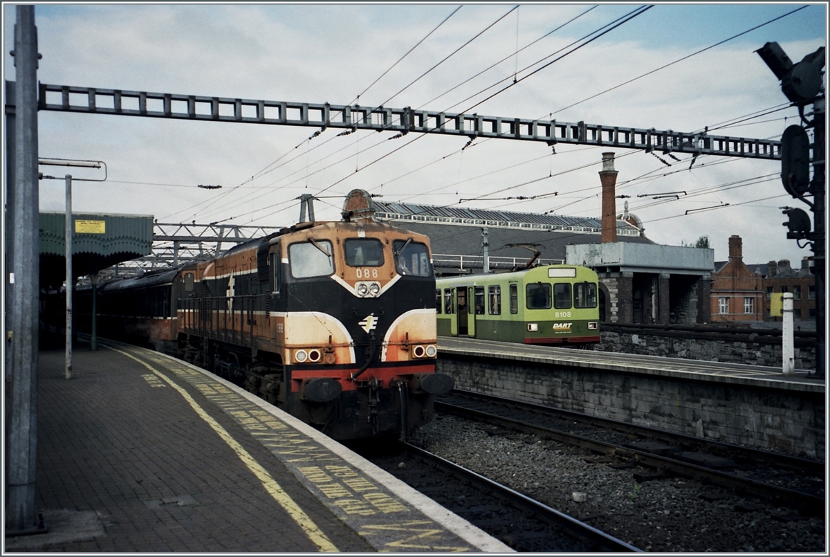 In Baile Átha Cliath Stásiún Uí Choghaile - besser bekannt als Dublin Connolly Station zeigen sich die CIE IR BB 088 mit einem Fernreisezug und im Hintergrund der DART Triebwagen 8108. 

Analogbild vom Juni 2001