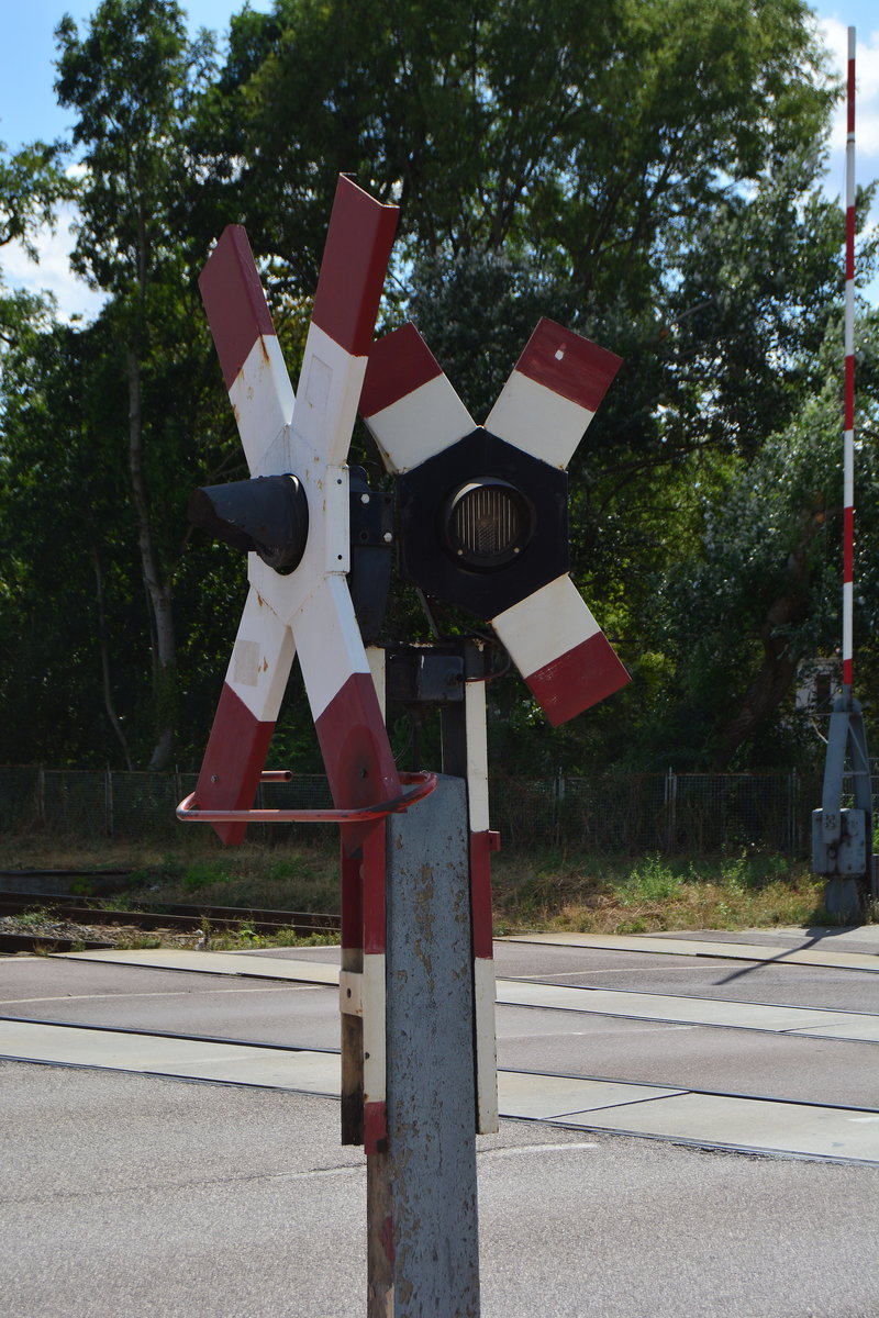 In Bernburg konnte ich dieses kleine Andreaskreuz am Bahnübergang Köthensche Straße finden. Aufgrund des fehlenden Platzes hat dieses nur 3 Arme. Auch die Schranken haben noch dünne Schrankenbäume.

Bernburg 27.07.2019