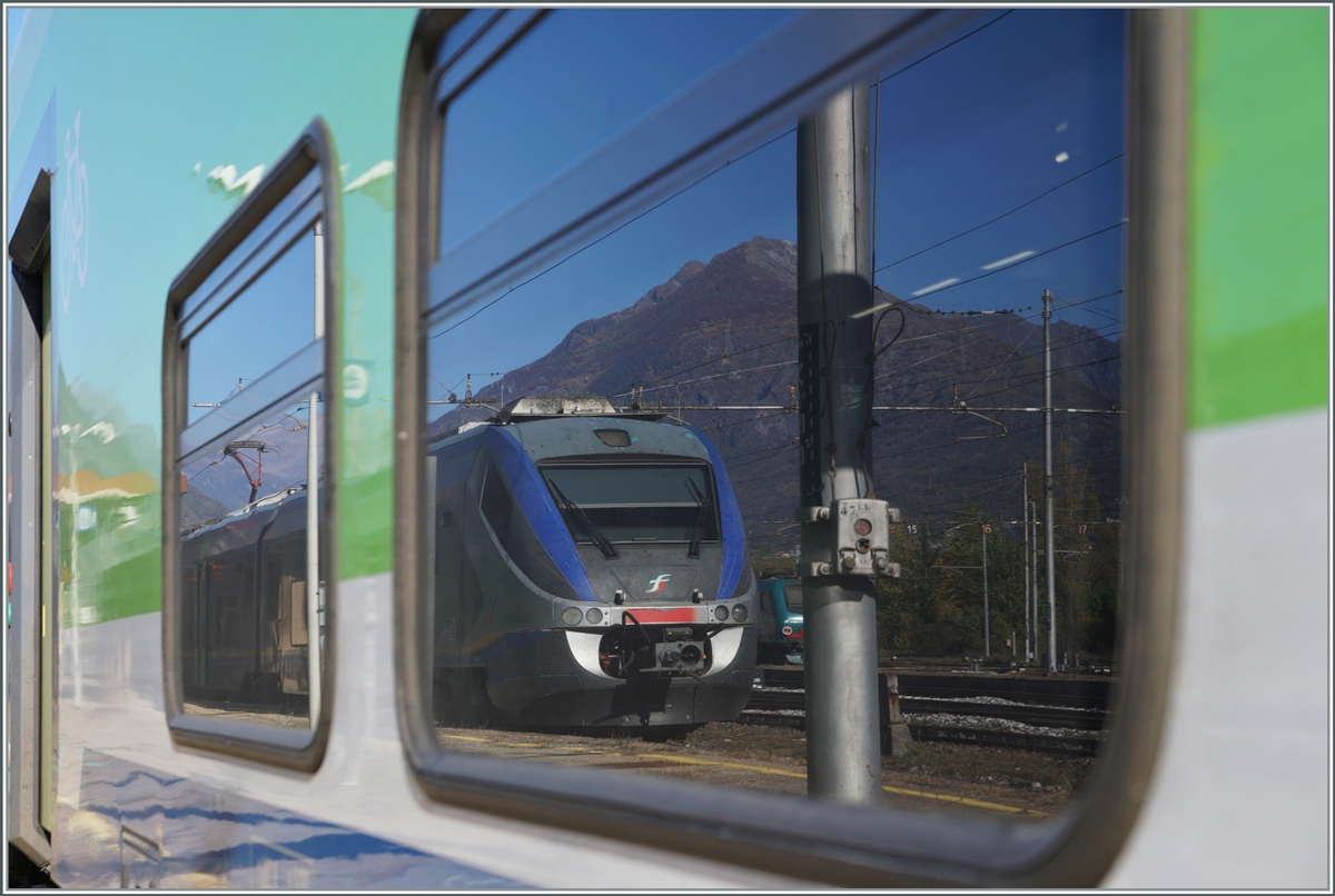 In des Fenstern des Trenord ROCK ETR 421 034 (UIC 94 83 4421 034-2 I-TN) spiegelt sich der  FS MINUETTO Ale 502 016-8 (UIC 94 83 4 502 016-8 I-TI). 

Domodossola, den 28. Oktober 2021