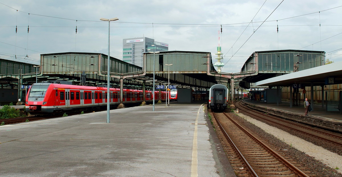 In diesem Jahr soll der Umbau des Duisburger Hauptbahnhofes beginnen. Dabei werden auch die aus den 1930er Jahren stammenden charakteristischen Hallendächer durch eine Neukonstruktion ersetzt. Es wird also langsam Zeit, dem Bahnhof noch einmal einen Besuch abzustatten. Am 03.05.2017 verlässt ein 422-Doppel den Hauptbahnhof Richtung Süden. Auf Gleis 10 ist der Schlusswagen eines IC nach Emden zu sehen.