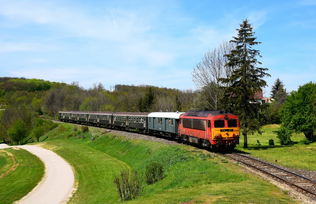 In diesem Jahr wird die M41-Serie in Ungarn 50 Jahre alt. Die MÁV-Start organisiert das ganze Jahr über landesweite Veranstaltungen mit diesem Typ. Diese Lokomotiven sind bereits von der Linie 11 verschwunden. Deshalb ist diese Veranstaltung gut: Die 418 128 fährt mit einem Retro-Zug zwischen Győr und Veszprém.
Auf dem Bild fährt der Zug 39514 von Győr nach Veszprém in der Nähe von Eplény.
Eplény, 01.05.2023