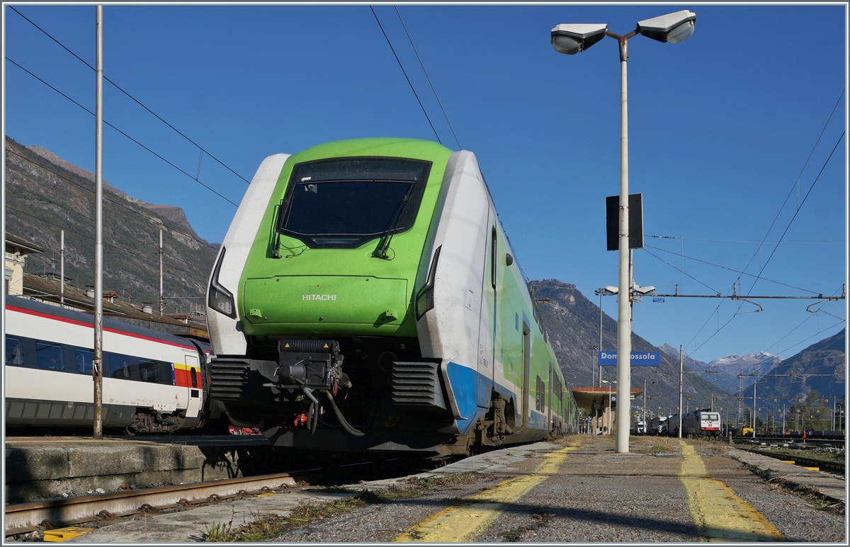 In Domodossola wartet der Trenord ETR 421 017 (94 83 4421 817-7 I-TN) auf seinen nächsten Einsatz; er wird als Trenord Regio 2431 um 14:56 nach Milano abfahren. 
Der Standort des Zugs und der unpassend kurze Bahnsteig erlauben im Rahmen der Gelben Linien nur ein Bild aus dieser Perspektive.

22. Oktober 2021