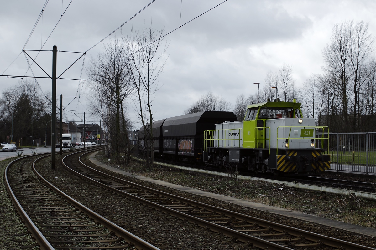 In Duisburg-Hüttenheim verläuft die Güterzugstrecke von den Hüttenwerken Krupp-Mannesmann nach Duisburg-Hochfeld Süd parallel zu den Gleisen der DVG-Straßenbahnlinie 903, am 18.02.2020 ist hier die MaK G 1203 BB 821 von Captrain entlang der Ehinger Straße unterwegs