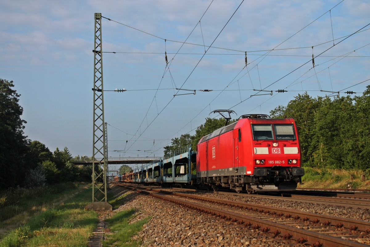 In den ersten Sonnenstrahlen des 11.07.2013 fuhr 185 082-5 mit einem leeren Autowagenzug aus Italien nach Lahr (Schw). Hier durchfhrt der Zug die letzte Ortschaft vor dem Endbahnhof. (Orschweier)