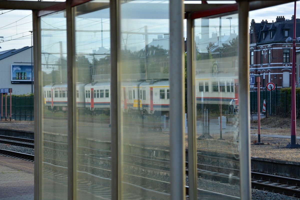 In den Fensterscheiben der Wartehäuschen im Bahnhof Mouscron/Mouskroen spiegeln sich die zahlreichen abgestellten Triebwagen wieder.

Mouscron/Mouskroen 15.07.2016