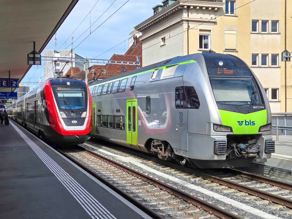 In Fribourg f�hrt ein SBB RABe 502 mit dem IC1 nach Genf Airport neben BLS MUTZ 018 mit der S1 nach Thun, 29.08.2026.