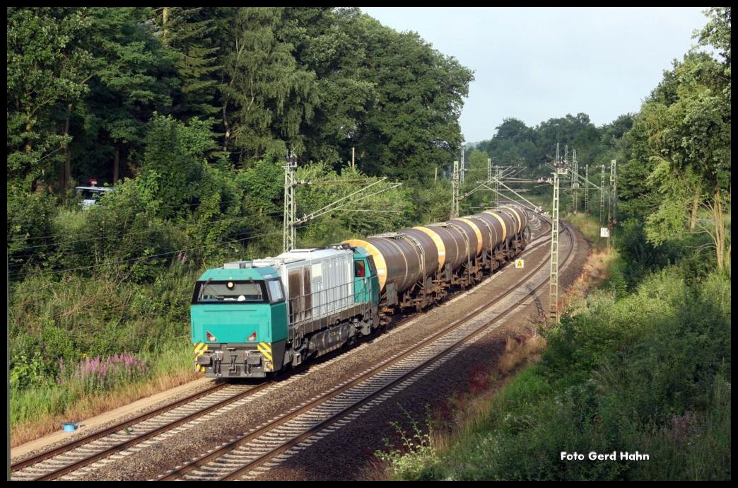 In der frühen Morgensonne kommt am 8.7.2015 um 7.06 Uhr in Vehrte eine G2000 Miet Lok der Bentheimer Eisenbahn mit einem leeren Kesselwagenzug in Richtung Barntrup fahrend um die Kurve.