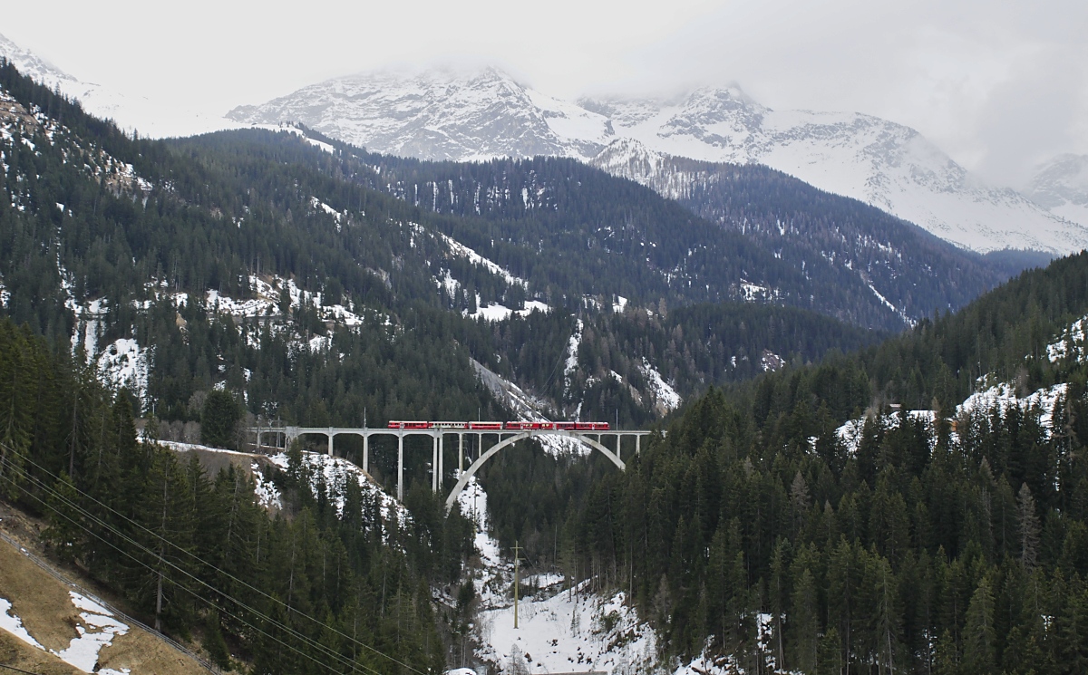 In der grandiosen Landschaft der Weissfluhgruppe wirkt nicht nur der von einem ABe 8/12 geführte Zug der Arosabahn, sondern auch der 284 m lange und 62 m hohe Langwieser Viadukt winzig. Gut erkennbar ist aber, wie perfekt er sich in die Landschaft einfügt.