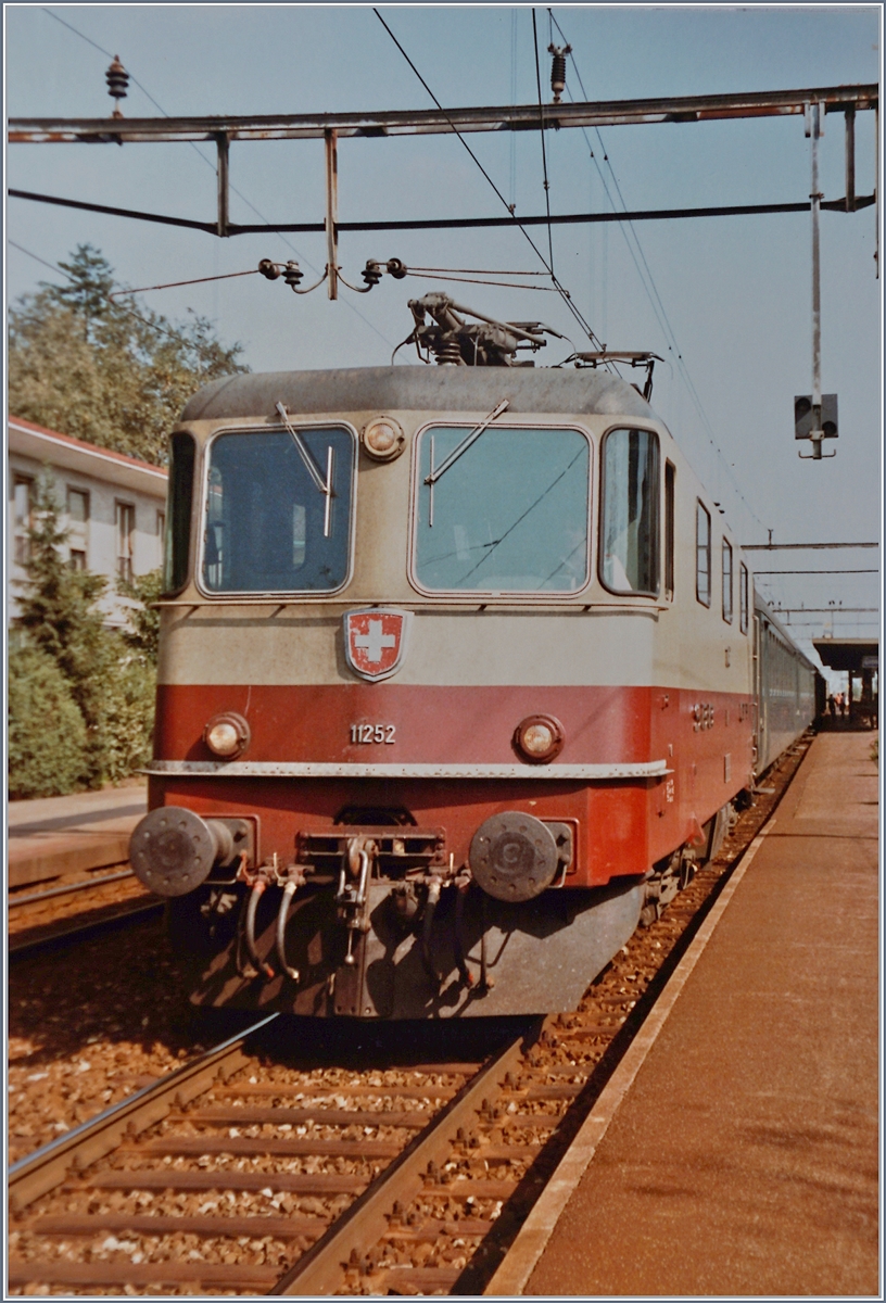 In Grenchen Süd wartet die SBB Re 4/4 II 11252 mit ihrem Schnellzug nach dem kurzen Halt auf die Weiterfahrt in Richtung Biel/Bienne. 

8. Oktober 1984