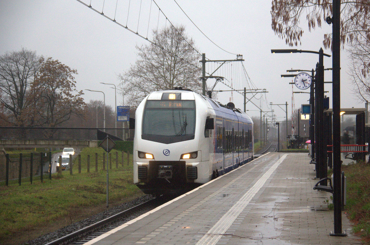 in Holländischer Regionalzug aus Maastricht-Randwyck(NL) nach Roermond(NL) und fährt in Geleen-Lutterade ein und hält in Geleen-Lutterade(NL) und fährt dann weiter in Richtung Sittard(NL). 
Aufgenommen in Geleen-Lutterade(NL).
Bei Regenwetter am Nachmittag vom 23.12.2018.