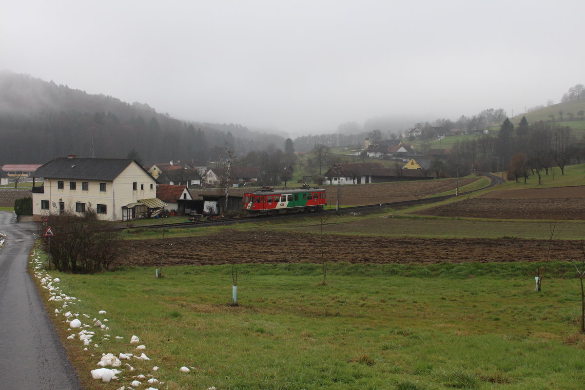 In der hügeligen Oststeiermark fährt am 7.12.2020 der ET2 der Steiermarkbahn als R8602 von Bad Gleichenberg nach Feldbach hier bei Oedt.
