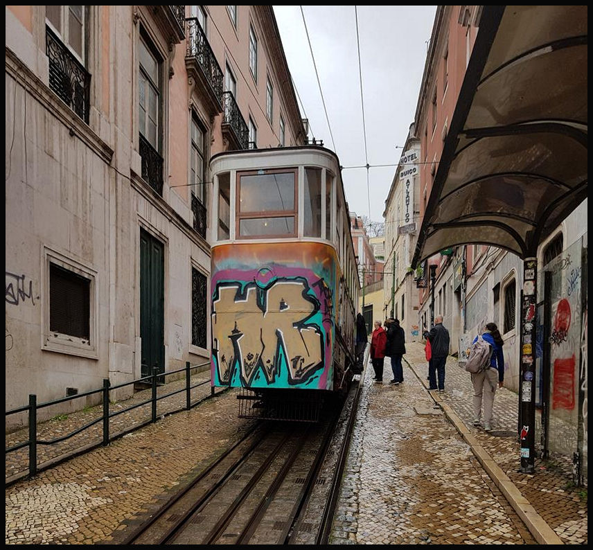 In Lissabon befindet sich im nordwestlichen Teil des Praca dos Restauradores in der Taberna da Gloria diese Standseilbahn. Obwohl die Bahn hemmungslos ohne Sinn und Verstand besprüht waren, möchte ich sie dennoch dokumentieren. Wir sehen hier am 19.3.2018 einen der beiden Wagen an der Talstation.